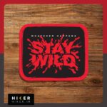برچسب ضد آب مستطیلی با حاشیه قرمز و پس‌زمینه مشکی که روی آن عبارت انگلیسی Whatever Happens Stay Wild با فونت کالیگرافی قرمز به سبک پاشش مایع یا رنگ طراحی شده است. مناسب شیشه ماشین آفرود و موتور