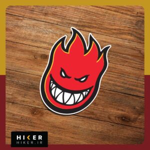 برچسب فانتزی لوگوی Spitfire با طرح شعله آتش خشمگین و خندان با تم رنگی مشکی، قرمز و زرد مناسب برای تزیین اسکیت‌بورد، لپ‌تاپ و ماشین.