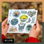 چند شیت استیکر با موضوع طبیعت‌گردی، حفاظت از محیط‌زیست و حیات‌وحش شامل شعارهایی مثل «فقط ردپا به جا بگذار» و «حیات‌وحش را نجات دهید در دستان یک زن در طبیعت پاییزی