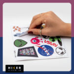 مجموعه‌ای از برچسب‌ها شامل: فضانوردی که روی یک سیارک در حال مدیتیشن است، بادکنک‌هایی به شکل سیارات منظومه شمسی در دست یک فضانورد کوچک، سرهای بیگانه سبز، جمجمه‌های فانتزی شکسته، و یک هیولای تک‌چشم صورتی.