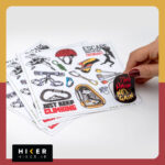 ورق استیکر با تم سنگ‌نوردی دارای تصاویری از ابزار صعود، فیگورهای سنگ‌نورد در حال صعود، گره طناب سبز، کارابین مشکی با طرح کوهستان و متن Just Keep Climbing، و استیکر دایره‌ای کارابین طلایی که منظره‌ای از چادر کوهنوردی و آبشار را در خود جای داده است.