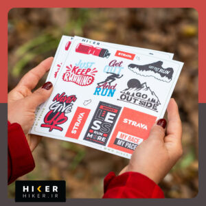 ورق استیکر با تم رانینگ حاوی طرح‌هایی از: فیگور دونده در حال حرکت، کفش دویدن با منظره جنگل، کوهستان با متن Go Outside، و استیکرهای مستطیلی با شعارهای ورزشی مانند Worry Less Run More و My Race My Pace در رنگ‌های نارنجی، مشکی و قرمز.